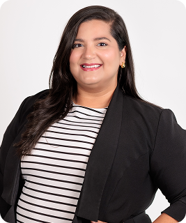 Woman smiles, wearing black blazer over striped shirt, against white background.